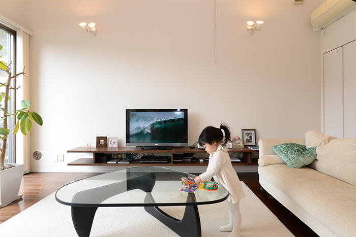 テレビ台は、角田さんが考案し、大工さんによる造作。デッキやリモコン類などがすっきりと納められている。家族写真も美しくディスプレイ。